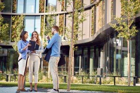 Women and man coworkers talking outside the building