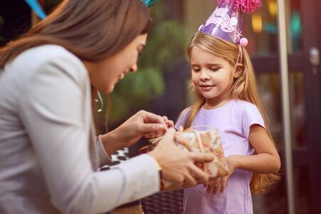 Mother  celebrate happy child girl   birthday and give presents.の写真素材