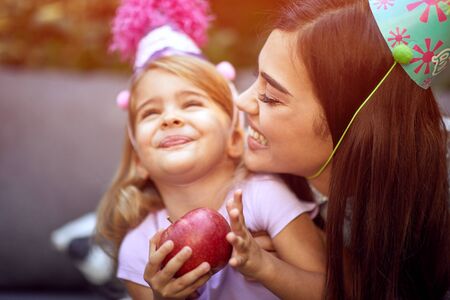 Happy girl  celebrate birthday and  eating fruit with her mother.の写真素材