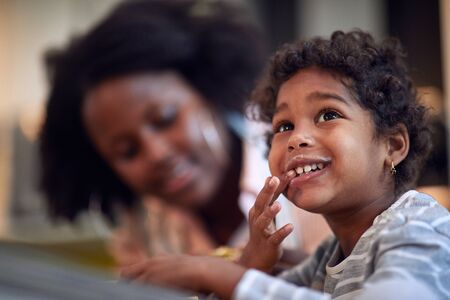 Happy girl with moustache from milk at breakfast at her mother.の写真素材