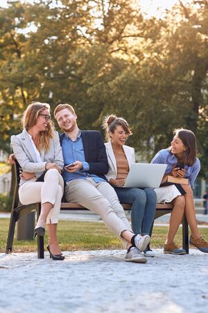 Group of young businesspeople hanging in a parkの写真素材
