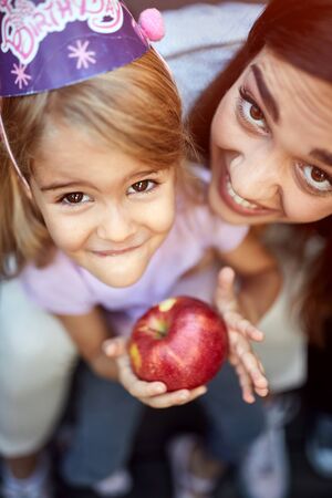 Top view of mother with daughter with apple