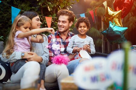 Happy male and female with kids celebrate birthdayの写真素材