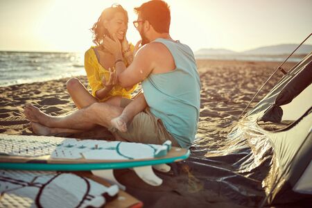 Romantic  smiling couple camping on the beach during the sunset.の写真素材