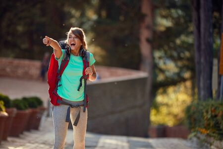 young female delighted by sightseeing in italy, showing thrilled with index finger what she sawの写真素材