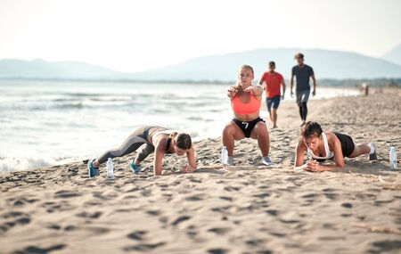 Sporty young girls on the beach practicing.Healthy lifestyle on vacation.