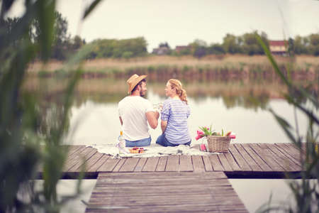 Back view on  young man and woman ho celebrating with wine at picnic.の写真素材