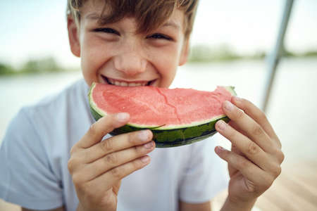 Cute boy  eating fresh watermelon.Summer joy sweet red watermelon.