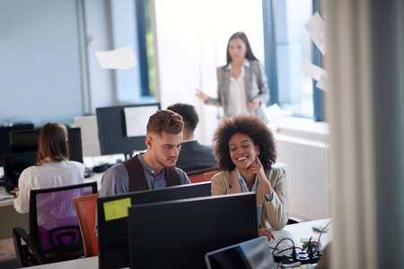 Young male and female colleagues working together and consulting in the office
