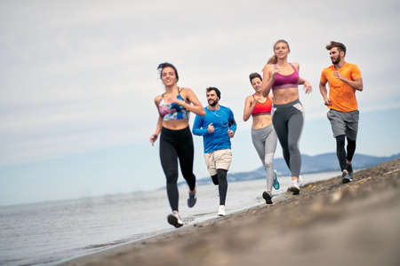 Group of friends training together on the beachの写真素材