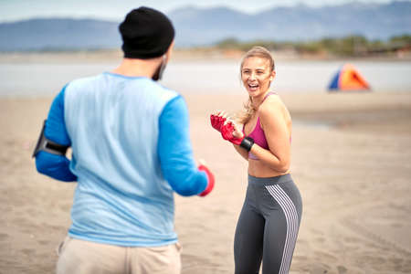 Woman training kickbox with a coach on the beachの写真素材