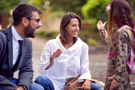 Dad, mom and daughter spending leasure time together talkingの写真素材