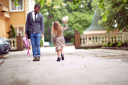 Father and daughter walking to the school togetherの写真素材