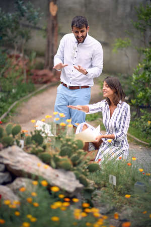 Smiling designer man and woman working exterior in flower gardenの写真素材