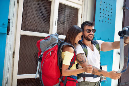 Happy couple with a backpack traveling and enjoying in vacation time taking picture.の写真素材