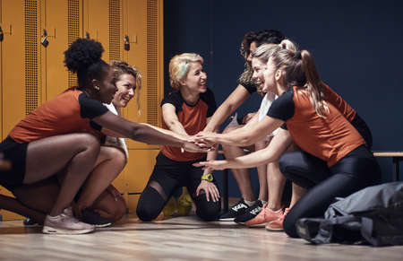 Female team building up the good spirit in a locker room before the gameの写真素材