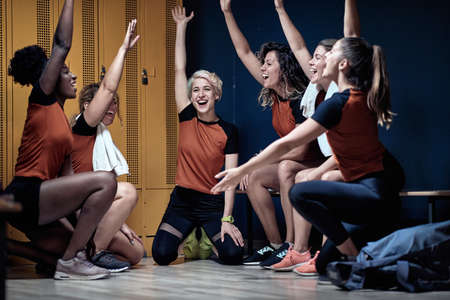 Female team in a locker room  happy after the win