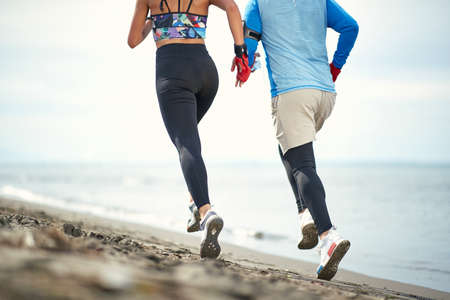 Young female boxer and her coach jogging on the beach on a beautiful weatherの写真素材
