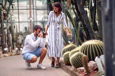 Male visitor with female guide taking photo of giant cactuses at the conservatoryの写真素材