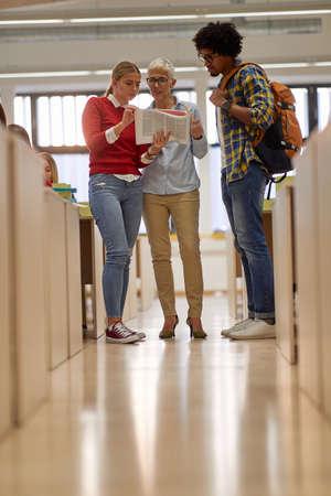 Students consultation with a professor about new lesson in the university classroom. Smart young...