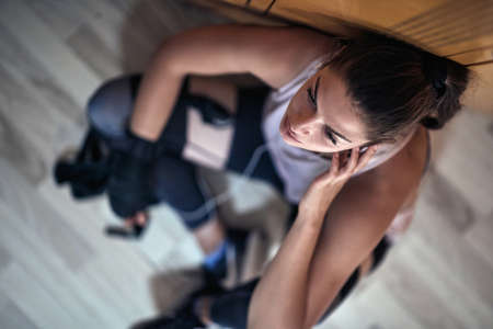 A young girl at the locker room relaxing and preparing for a training. Recreation, fitness and sportの写真素材