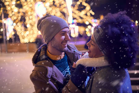 A young couple in romantic moments at ice rink on a beautiful night. Skating, closeness, love, togetherの写真素材