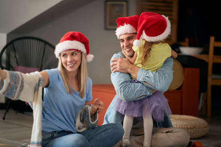 Happy parents spening Christmas time together with their kid; Family holiday conceptの写真素材
