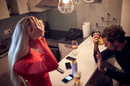 worried female trying to talk with drunk male. alcohol issue conceptの写真素材