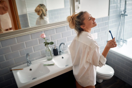Young handsome girl enjoying a beautiful morning in a relaxed atmosphere of the bathroom. Hygiene, bathroom, morningの写真素材