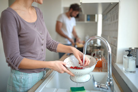 A young couple preparing a meal in the kitchen together. Kitchen, home, cooking, relationshipの写真素材