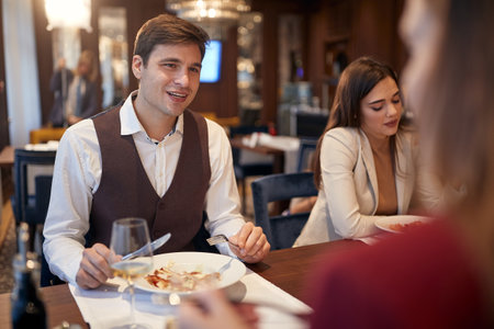 Young people enjoying eating lunch in a relaxed atmosphere at the restaurant. Business, restaurant, lunchの写真素材