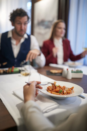Young business people enjoying the food in a pleasant atmosphere during a lunch at the restaurant. Business, restaurant, lunchの写真素材