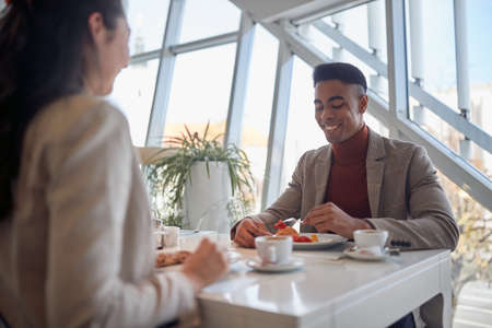 multiethnic young people at lunch break, talking, eating, drinking coffee