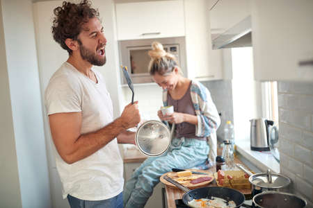 Happy couple making breakfast together in the kitchenの写真素材