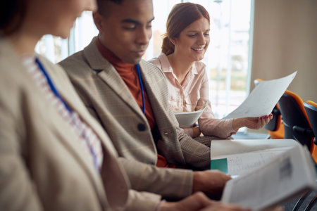 multiethnic group of young people reading scripts at business seminar in conference room, exchanging...