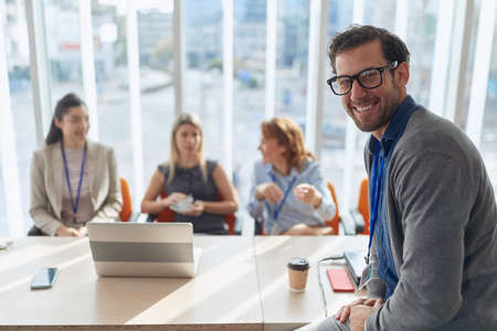 portrait of young caucasian manager at business meeting. eye contact, looking at camera, smilingの写真素材