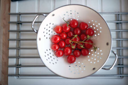 Washed fresh cherry tomatoes in the colander. Vegetables, kitchen, homeの写真素材