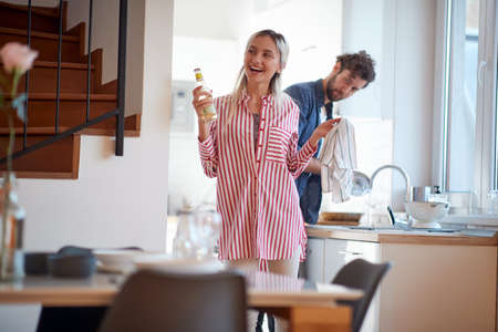 Young couple in sharing housework on a beautiful day. Kitchen, housework, home, relationshipの写真素材