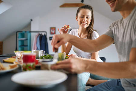 A young couple in love loves to have a breakfast in a relaxed atmosphere at home. Couple, home, breakfast, togethernessの写真素材