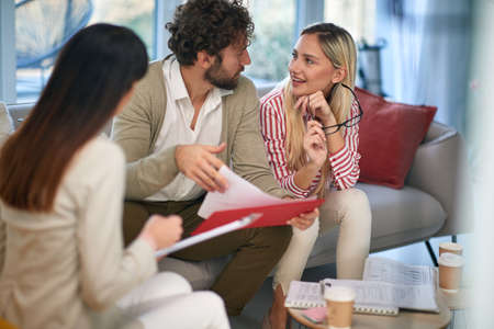 A group of young business people at a meeting in a relaxed atmosphere discussing plans for a new...