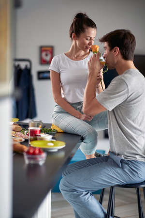 A young girl enjoying flower she got from his boyfriend during a breakfast in a relaxed atmosphere...