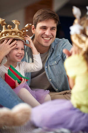 Dad playing with his little daughters in a cheerful atmosphere at home. Family, playing, home, togethernessの写真素材