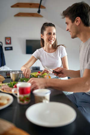 Cheerful romantic cople having breakfast together at homeの写真素材