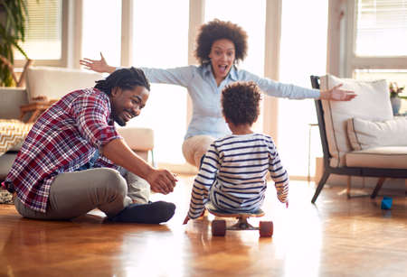 A happy parents playing with their son on the floor in a cheerful atmosphere at home. Family,...