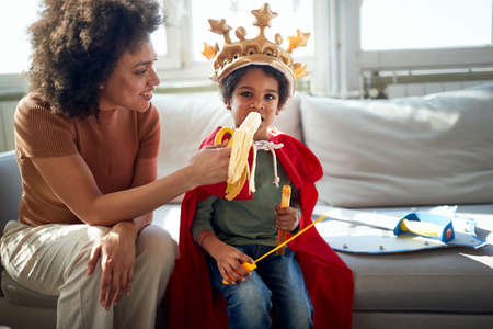 A little boy enjoying a banana while playing with his Mom in a relaxed atmosphere at home. Family, together, love, playtimeの写真素材