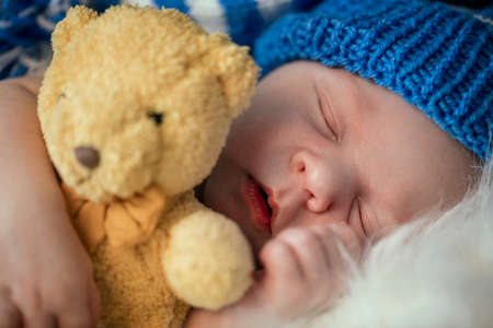 Sweet baby sleep in hug with teddy bearの写真素材