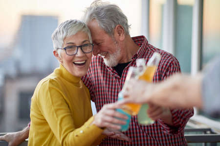 An older couple drinking and celebrating togetherの写真素材