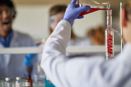 A young female scientist doing an experiment in a working atmosphere at the university laboratory. Science, chemistry, lab, peopleの写真素材