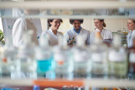 Young chemical students discuss molecule model in a relaxed atmosphere in the university laboratory. Science, chemistry, lab, peopleの写真素材