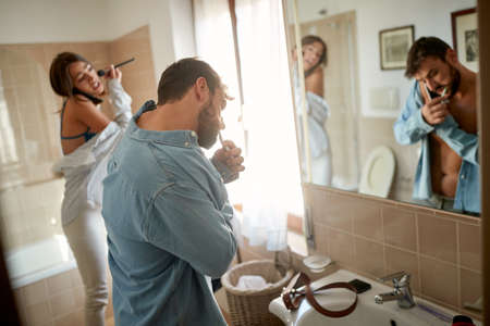 Modern couple preparing for the day together in the morningの写真素材
